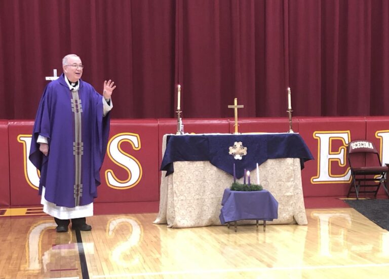 A priest says Mass at Scecina