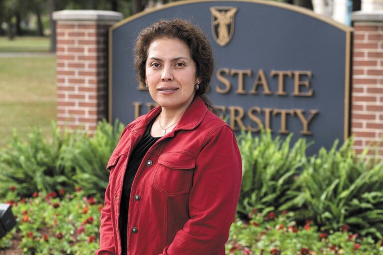 Susana Rivera-Mill standing next to Ball State University sign